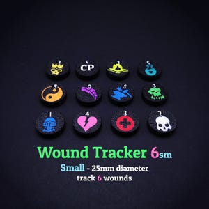 Può includere: Un set di dodici segnalini neri per il tracciamento delle ferite con vari simboli e numeri colorati. Il testo "Wound Tracker 6sm" e "Small - 25mm diameter track 6 wounds" è visualizzato in verde. Ogni segnalino ha un diametro di circa 2,5 cm.