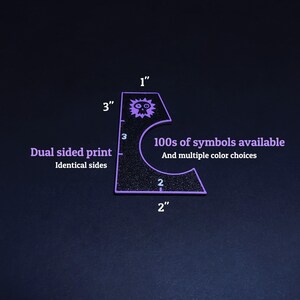 May include: A black, glitter-textured, purple-edged stencil with a skull symbol and the text "100s of symbols available". The stencil is 3 inches tall and 2 inches wide. The text "Dual sided print" is also visible.