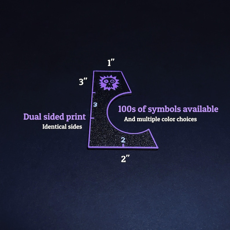 May include: A black, glitter-textured, purple-edged stencil with a skull symbol and the text "100s of symbols available". The stencil is 3 inches tall and 2 inches wide. The text "Dual sided print" is also visible.