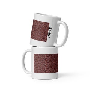 Peut inclure: Deux tasses en céramique blanche empilées verticalement. Chaque tasse présente un imprimé graphique rectangulaire de grains de café torréfiés brun foncé au centre. La tasse supérieure porte le mot COFFEE imprimé verticalement en lettres noires.