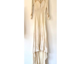Abito da sposa vintage in raso avorio, stile edoardiano, con pizzo e strascico asimmetrico.