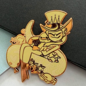 May include: A yellow enamel pin featuring a cartoon character with a top hat and a duck. The pin has a gold outline and is surrounded by other cartoon characters. The pin is on a dark surface.