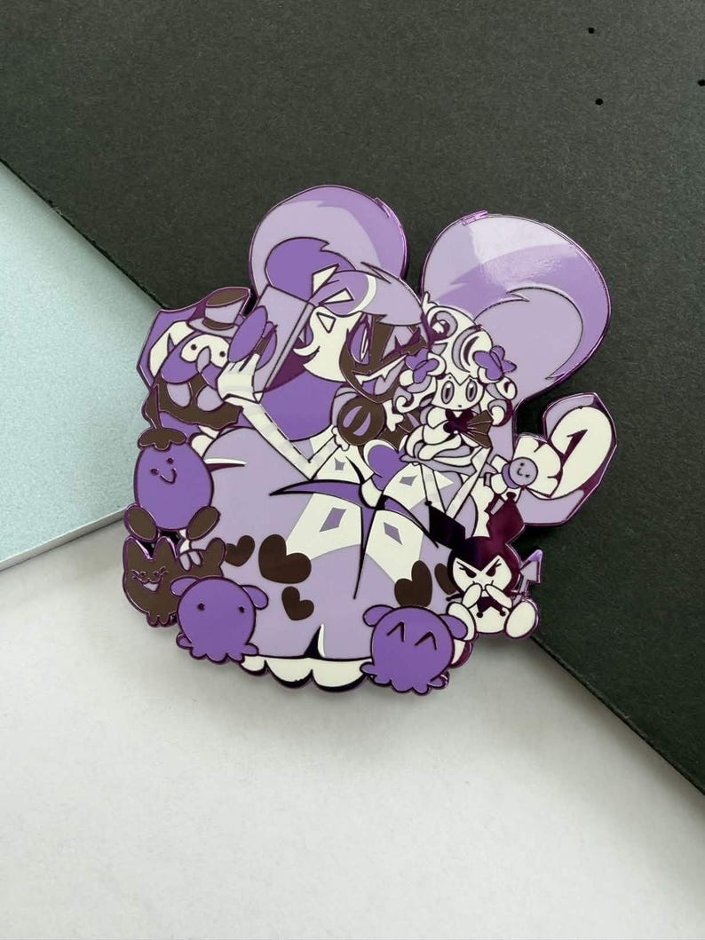 May include: A purple enamel pin featuring a cartoon illustration of several characters. The pin has a white border and a glossy finish. The characters are in shades of purple, brown, and white.