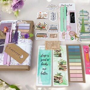 May include: A collection of book-themed items, including stickers, bookmarks, pens, and a gift box with a "Fantasy" tag. The items are arranged with floral accents and include a reading list and a variety of decorative elements.