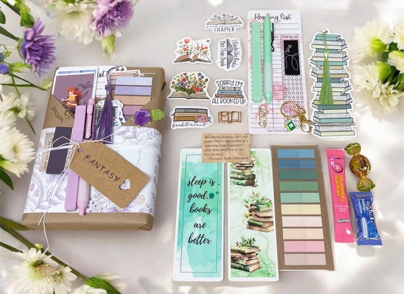 May include: A collection of book-themed items, including stickers, bookmarks, pens, and a gift box with a "Fantasy" tag. The items are arranged with floral accents and include a reading list and a variety of decorative elements.
