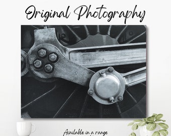 Original monochrome close-up photograph of a detail of the drive rod and eccentric crank on the wheel of a vintage steam train.