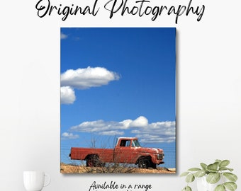 Original colour photograph of a faded red 1960s American pick-up truck, abandoned and rusting away in the mid-West USA under a blue sky.