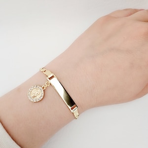 Pulsera chapada en oro con dije de Nuestra Señora de Guadalupe y eslabón de identificación
