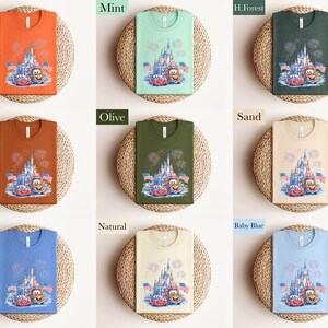 The image is a collage of nine different t-shirt designs, each with a unique color and pattern. The t-shirts are arranged in a 3x3 grid, with each row containing three shirts. The designs include a castle, fireworks, and cartoon characters. The colors of the t-shirts are orange, mint, green, and blue.