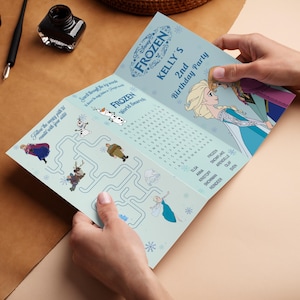 May include: A light blue tri-fold party invitation with the text "FROZEN" and "KELLY'S 2nd Birthday Party". The invitation features illustrations of characters from the movie Frozen and a word search puzzle.