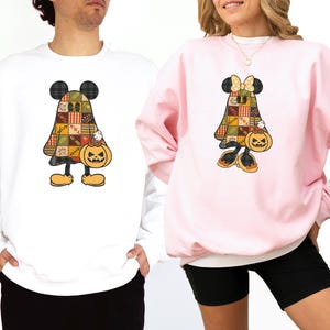 Puede incluir: Una sudadera blanca y una sudadera rosa claro, cada una con un gráfico de un personaje de dibujos animados vestido de fantasma con un patrón otoñal de patchwork, sosteniendo un cubo de calabaza para Halloween.