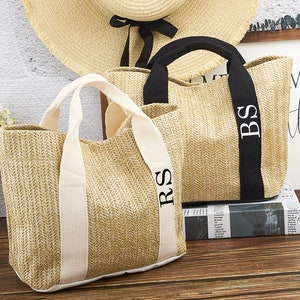 Puede incluir: Dos bolsos de mimbre con iniciales personalizadas. El bolso de la izquierda tiene asas blancas y las iniciales "RS" bordadas en el asa. El bolso de la derecha tiene asas negras y las iniciales "BS" bordadas en el asa.