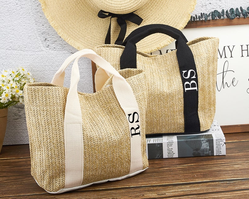 Puede incluir: Dos bolsos de mimbre con iniciales personalizadas. El bolso de la izquierda tiene asas blancas y las iniciales "RS" bordadas en el asa. El bolso de la derecha tiene asas negras y las iniciales "BS" bordadas en el asa.