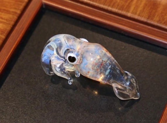 A hand-blown glass squid with swirling colorful flecks trapped inside — the kind of ocean creature sculpture that stops guests mid-conversation.
