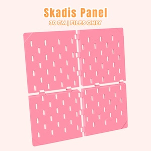 Pode incluir: Painel Skadis rosa, 30 cm, com múltiplos orifícios pequenos para organização. O painel é feito de plástico e foi projetado para ser modular. O texto "Skadis Panel" e "Files Only" são visíveis.