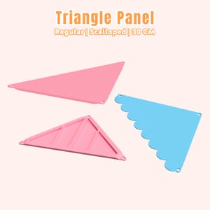 Op de afbeelding: Drie driehoekige panelen in roze en blauw. Eén roze paneel is normaal, een ander heeft een geschulpte rand en de derde heeft een geribbeld ontwerp. De tekst "Triangle Panel" staat bovenaan, met daaronder "Regular | Scalloped | 30 CM".