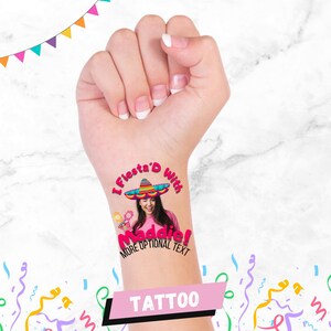 Op de afbeelding: Een tijdelijke tattoo met de tekst "I Fiesta'd With Maddie!" boven een foto van een persoon met een sombrero en maracas. Het woord "Tattoo" staat in een roze banner onderaan.