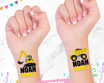 May include: Two temporary tattoos featuring yellow construction vehicles. One tattoo shows a yellow excavator with the text "Noah Turns 3". The other tattoo shows a yellow dump truck with the text "Noah Turns 3".