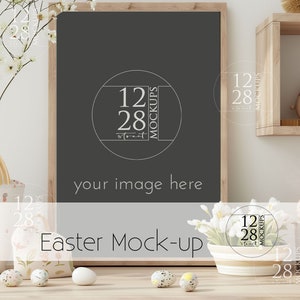 Könnte beinhalten: Eine schwarze gerahmte Tafel mit dem Text "your image here" und einem weißen Kreis mit dem Text "12 28 MOCKUPS" in der Mitte. Die Tafel steht auf einem Holztisch mit einer weißen Schale mit Blumen, einem Korb mit Ostereiern und einem Korb mit einem Hasendesign.
