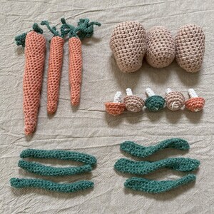 Puede incluir: Un conjunto de juguetes de comida de crochet, que incluye zanahorias, patatas, champiñones y judías verdes. Los juguetes están hechos con hilo suave y son perfectos para juegos de simulación.