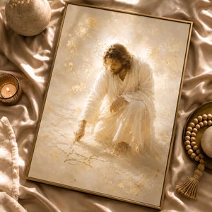 May include: A framed rectangular wall art print featuring a figure with long hair and a beard, dressed in white robes, kneeling and touching the ground. The artwork uses a soft, warm color palette with gold leaf accents and a hazy, ethereal light.