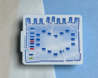 Könnte beinhalten: Ein blauer und weißer Aufkleber mit einem rissigen Design. Der Aufkleber zeigt ein Raster aus blauen und schwarzen Quadraten mit einem roten und gelben Streifen. Der Text "@shoplabass" befindet sich an der Seite des Aufklebers.