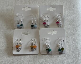 May include: Four pairs of dangle earrings on white display cards. Each pair features silver-tone metal hooks and short chains with small, colorful beads in various shades including blue, green, pink, white, orange, and yellow, arranged in pairs.