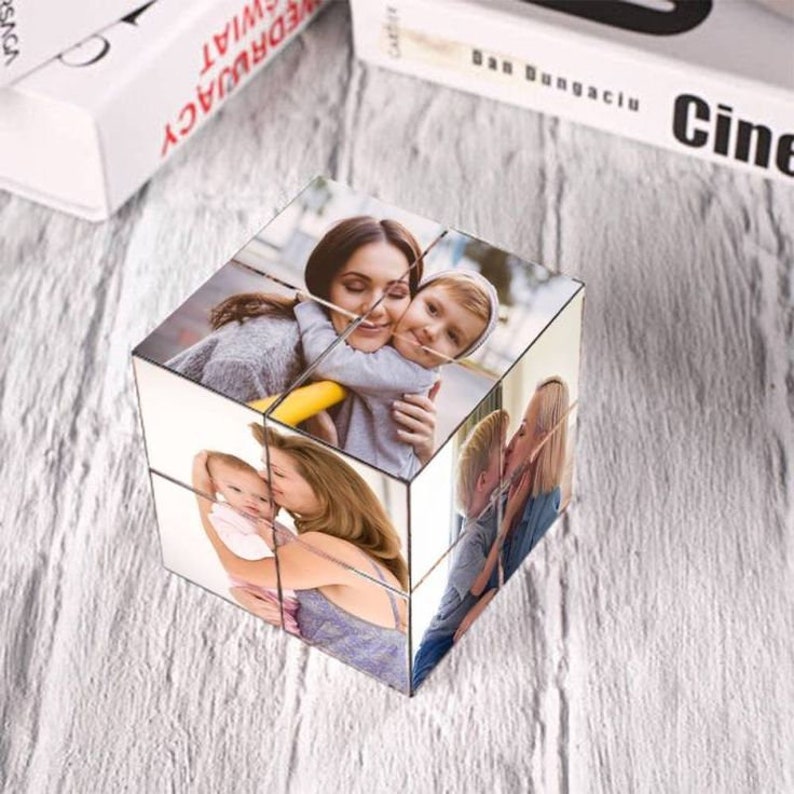Pu&ograve; includere: Un cubo fotografico con sei immagini diverse di una famiglia. Il cubo &egrave; in metallo e ha una finitura argentata. Le foto mostrano una madre e i suoi due figli.