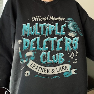 May include: Black sweatshirt with a blue and white graphic design that says "Official Member Multiple Deleters Club Leather & Lark". The graphic also includes a bird, musical notes, and a skull.