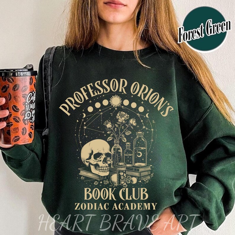 May include: A forest green sweatshirt with the text "Professor Orion's Book Club Zodiac Academy" in a vintage style font. The design features a skull, flowers, and potion bottles.