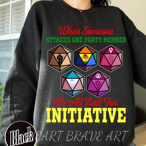 May include: Black sweatshirt with the text "When Someone Attacks One Party Member, We All Roll For Initiative." Features colorful dice with various symbols. The brand name "Black Cart Brave Art" is in a circle at the bottom.