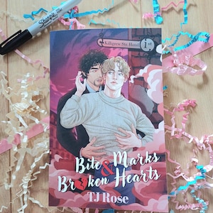 Może przedstawiać: Okładka książki "Bite & Marks Broken Hearts" autorstwa TJ Rose. Okładka przedstawia dwóch mężczyzn obejmujących się, z ciemnym tłem i tekstem "Killigrew Str. Hotel 1st". Czarny marker i dekoracyjne serpentyny są również widoczne.