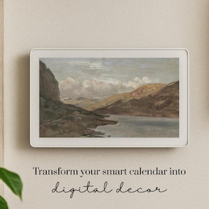 May include: A digital display with a landscape painting of a lake and mountains. The display is in a white frame and mounted on a beige wall. Text below reads "Transform your smart calendar into digital decor."