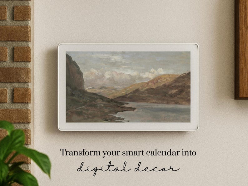 May include: A digital display with a landscape painting of a lake and mountains. The display is in a white frame and mounted on a beige wall. Text below reads "Transform your smart calendar into digital decor."