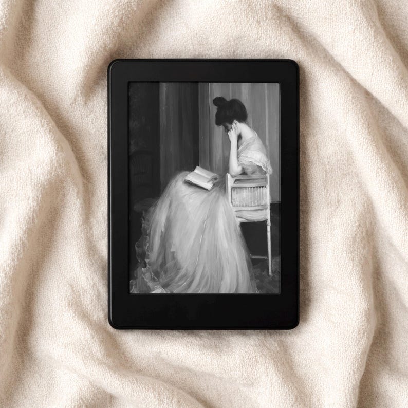 May include: A black e-reader displaying a black and white image of a woman in a long dress seated on a chair, with a book in her lap. The e-reader rests on a cream-colored, textured surface.