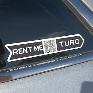 May include: A black and white sticker on a silver car window that says "Rent Me" with a QR code and "Turo" with an arrow pointing to the right.