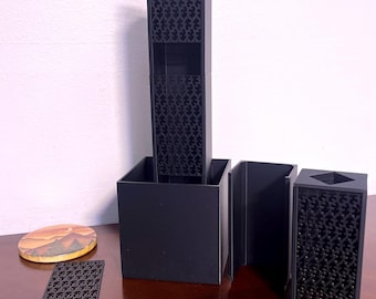 May include: A black 3D printed modular organizer with a geometric pattern. The organizer is made up of several pieces that can be assembled in different ways. The organizer is perfect for storing small items like pens, pencils, and other office supplies.