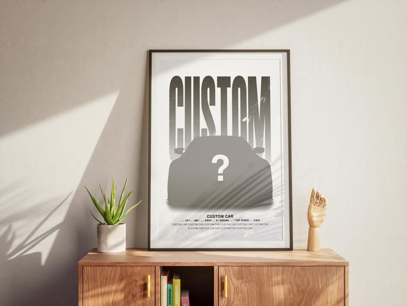 Puede incluir: Un p&oacute;ster en blanco y negro con la palabra "CUSTOM" en letras grandes y en negrita. Debajo de la palabra hay una silueta de un coche, con un signo de interrogaci&oacute;n en el medio del coche. El p&oacute;ster est&aacute; enmarcado en un marco negro y colgado en una pared.