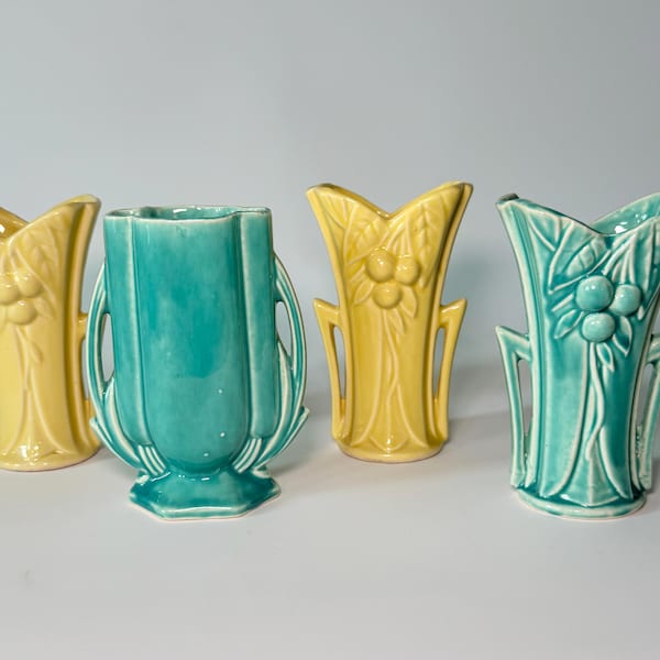 Peut inclure: Quatre vases en céramique jaunes et turquoise. Deux vases sont jaunes avec un motif de fruits, un est turquoise avec un motif cannelé, et le dernier est turquoise avec un motif de fruits. Décoration intérieure.