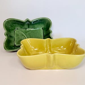 May include: A set of three ceramic nesting bowls with a speckled, cream-colored glaze. The bowls vary in size, with the largest measuring approximately 6 inches in diameter. Each bowl has a rounded shape and a simple, minimalist design.