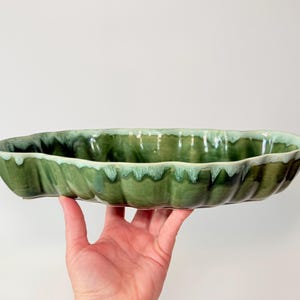 May include: A set of three ceramic mugs with a speckled, matte finish. Each mug features a different color: light blue, cream, and gray. The mugs have a simple, modern design and a comfortable handle.