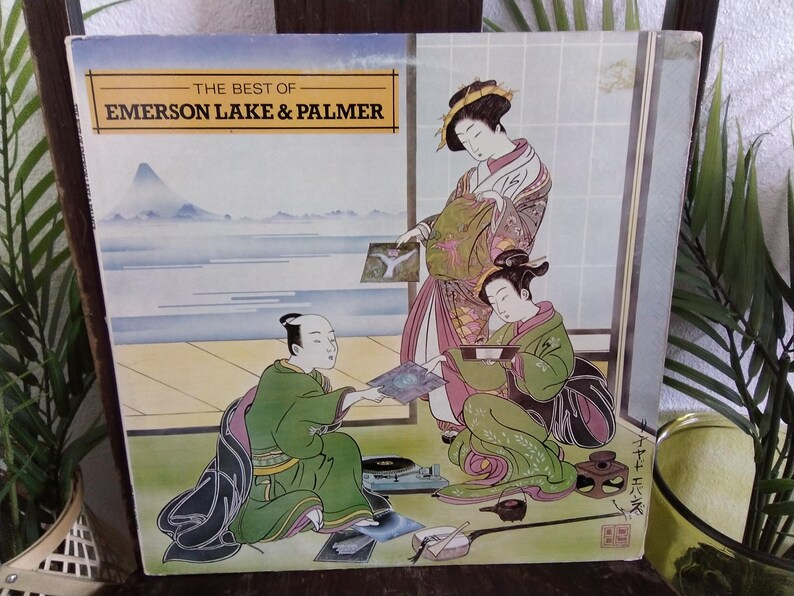 May include: Vintage vinyl record album cover for "The Best of Emerson, Lake & Palmer." The cover art features a Japanese-style illustration of three figures in traditional clothing, with a landscape in the background. The album cover is in good condition.