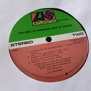 May include: A vintage vinyl record for "The Best of Emerson Lake & Palmer." The record label is green and red with the Atlantic Records logo. The tracklist includes "Fanfare for the Common Man" and "Trilogy."