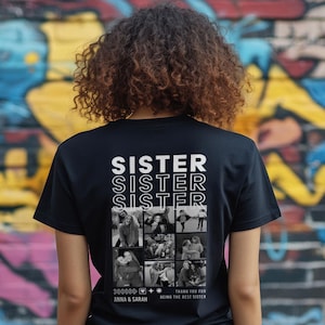 Op de afbeelding: Zwart T-shirt met het woord "SISTER" driemaal in het wit gedrukt. Daaronder staan ​​verschillende zwart-wit foto's. Het shirt bevat ook de tekst "THANK YOU FOR BEING THE BEST SISTER" en de namen "ANNA & SARAH".