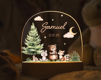 Könnte beinhalten: Personalisiertes Nachtlicht mit einer Waldszene, die einen Bären, einen Fuchs, einen Waschbären und andere Tiere zeigt. Der Name "Samuel" und das Datum "03.04.2025" sind auf der Acrylplatte auf einem Holzsockel abgebildet.