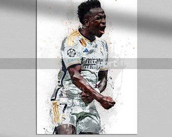 Puede incluir: Impresión artística digital de un futbolista con una camiseta blanca y dorada con el texto "Emirates Fly Better". El jugador celebra con los brazos en alto y la boca abierta. El fondo tiene salpicaduras de pintura blancas y grises.