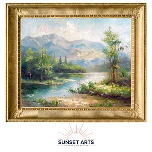 May include: A framed painting of a landscape scene with a lake, mountains, and trees. The painting is in a gold frame with a decorative border.