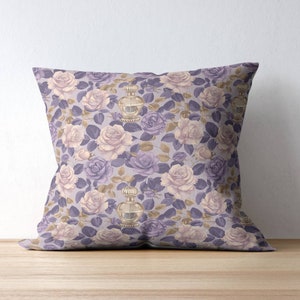 May include: A purple and cream throw pillow with a floral pattern featuring roses and perfume bottles.