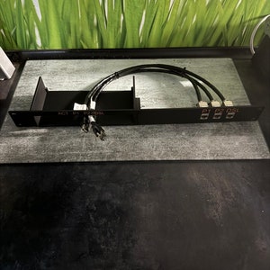 Könnte beinhalten: Schwarze Metallbox mit drei schwarzen Kabeln, die daran angeschlossen sind. Die Box ist mit den Bezeichnungen "ACT", "P1", "P2" und "DSL" beschriftet.