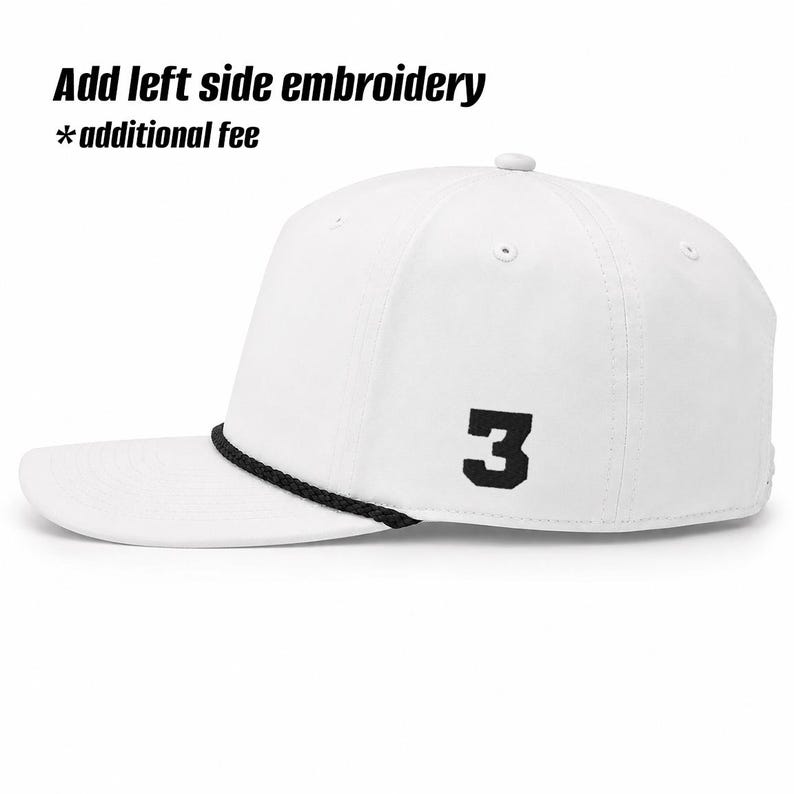 May include: A white baseball cap featuring a black braided cord across the base of the crown and a black embroidered number 3 on the side. The text Add left side embroidery *additional fee is visible at the top of the image.